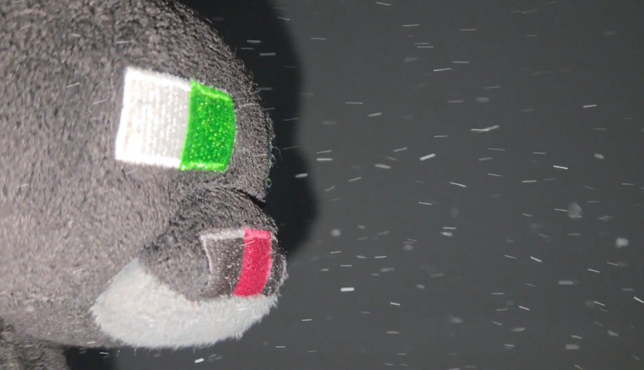 Grey plush character in falling snow